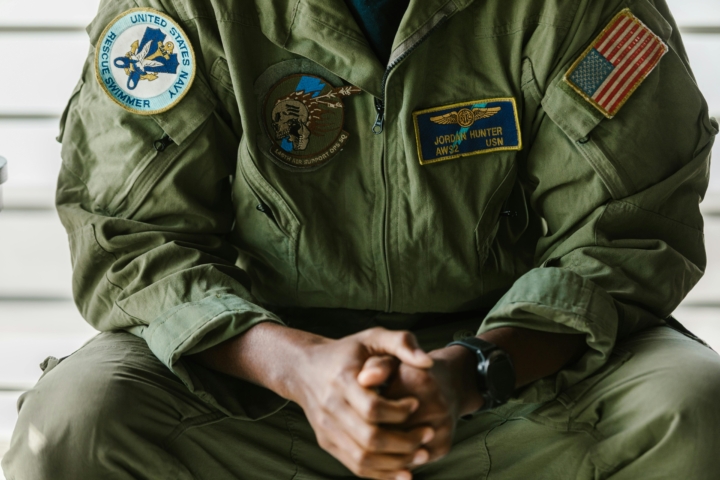 military man in cammo uniform with fingers interlaced by the rdne stock project