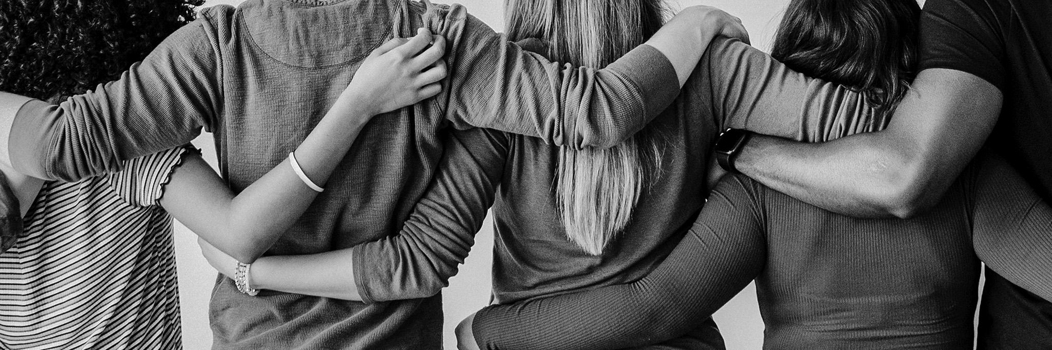 Rearview Of Diverse People Hugging Each Other
