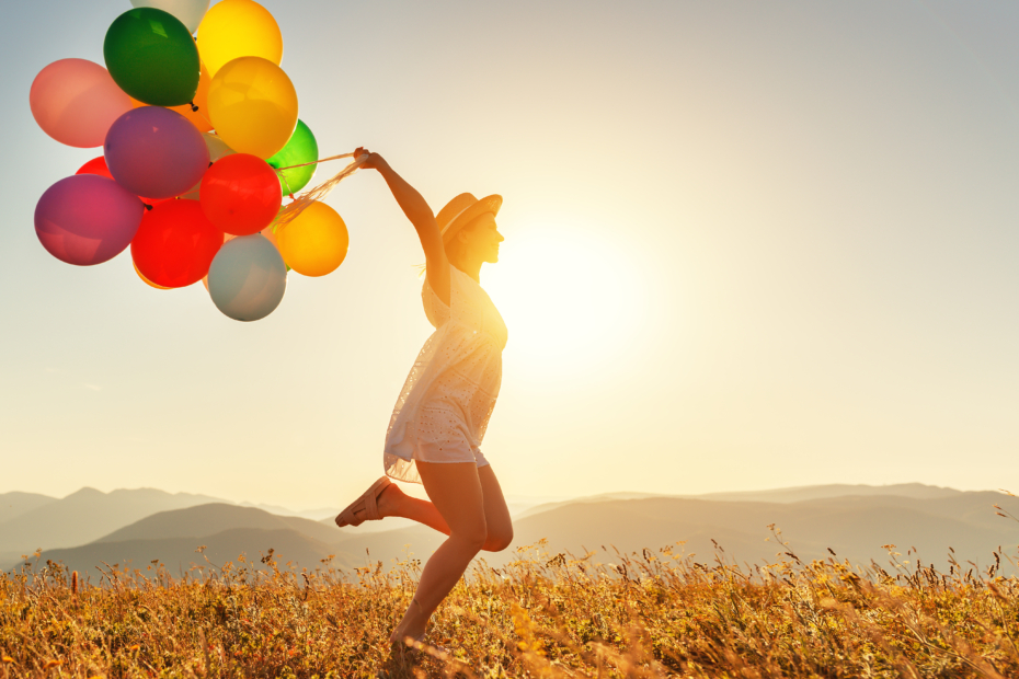 Happy Woman Running With Balloons At Sunset In Summer